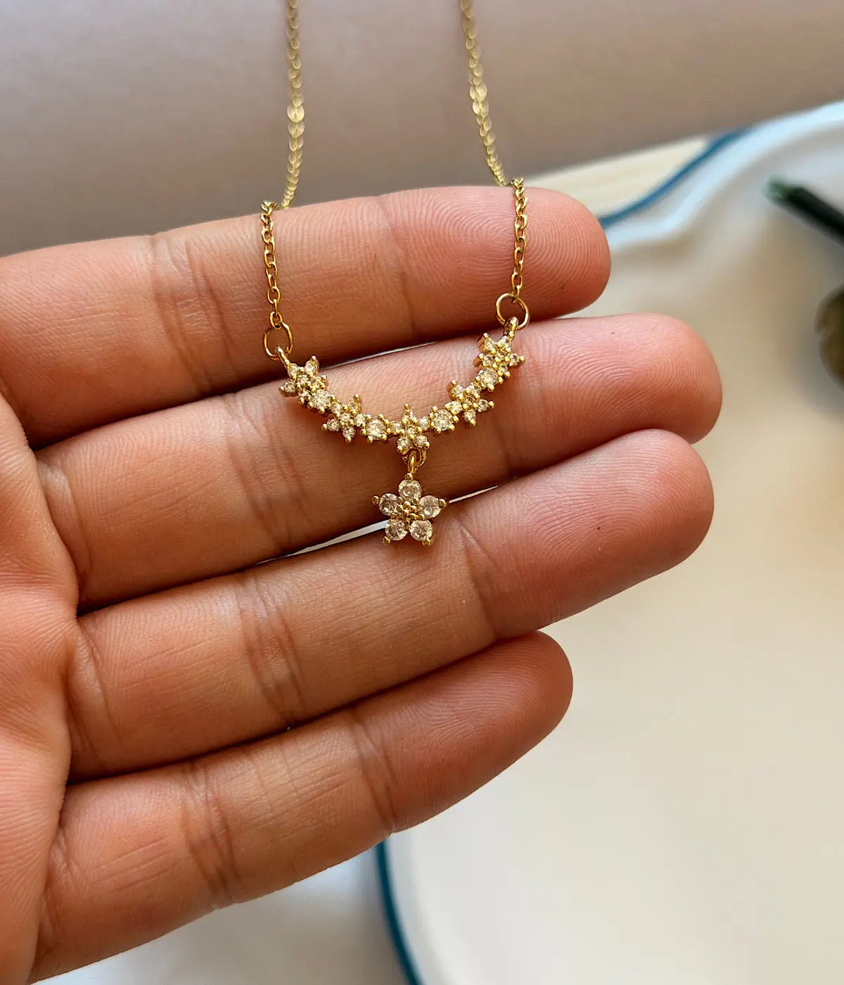 Çiçek motifli taşlı gold kadın kolye yakın çekim