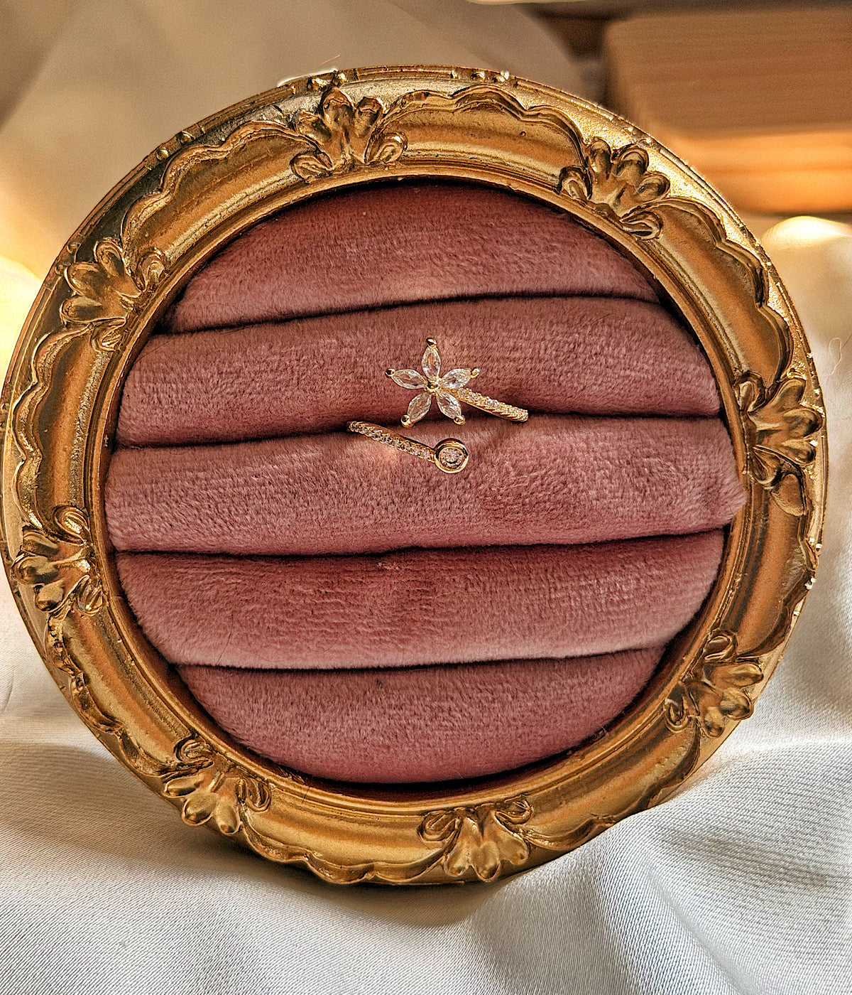 Çiçek ve tek taş detaylı gold yüzük pembe kadife sunumda