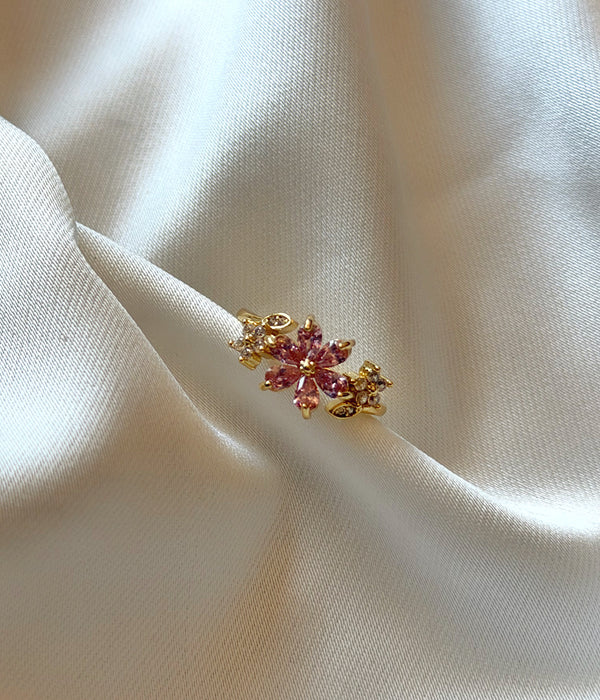 Pembe çiçek taşlı gold kadın yüzük beyaz saten üzerinde yakın görünüm