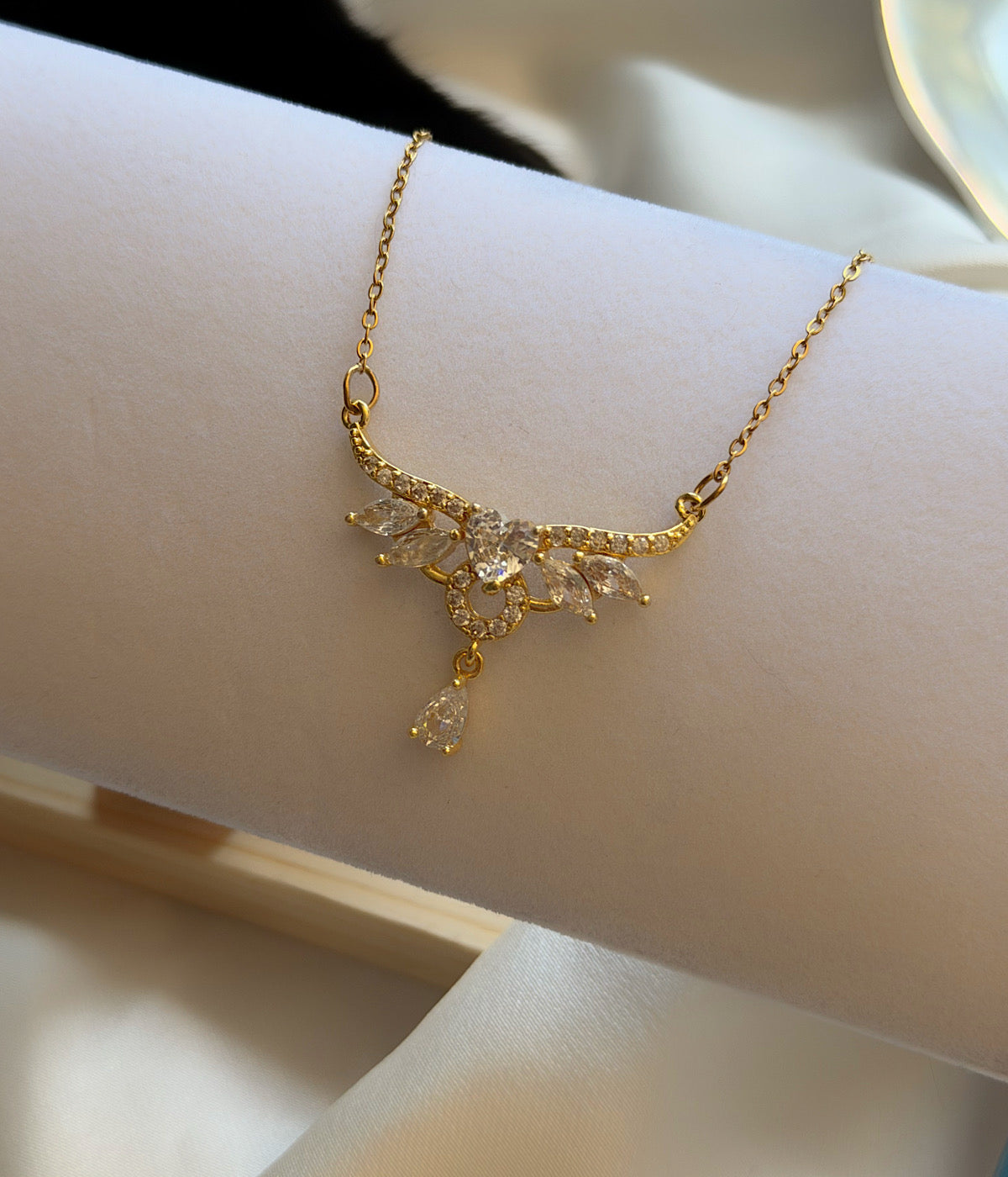 Merkezinde zirkon taş bulunan kanat ve damla detaylı gold kolye