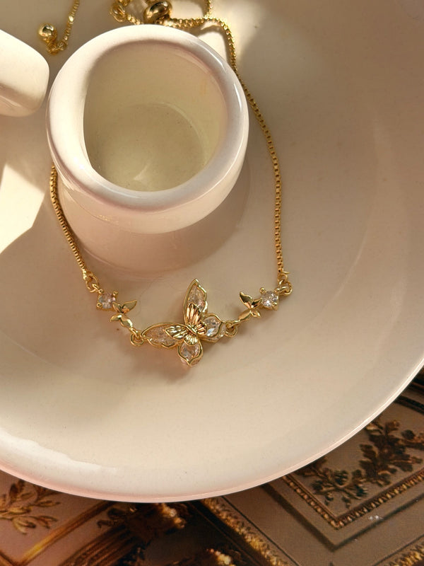 Gold kelebek figürlü ayarlanabilir bileklik, dekoratif tabak üzerinde ürün görünümü
