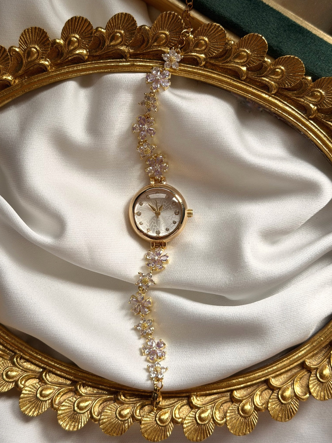 Lila ve beyaz çiçekli gold kadın saatin dekoratif gold çerçeve üzerinde dikey görünümü