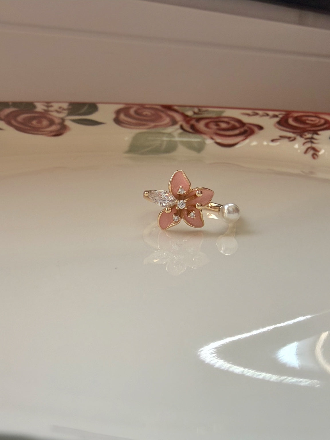 Pembe çiçek ve şeffaf taş detaylı ayarlanabilir gold yüzüğün önden görünümü