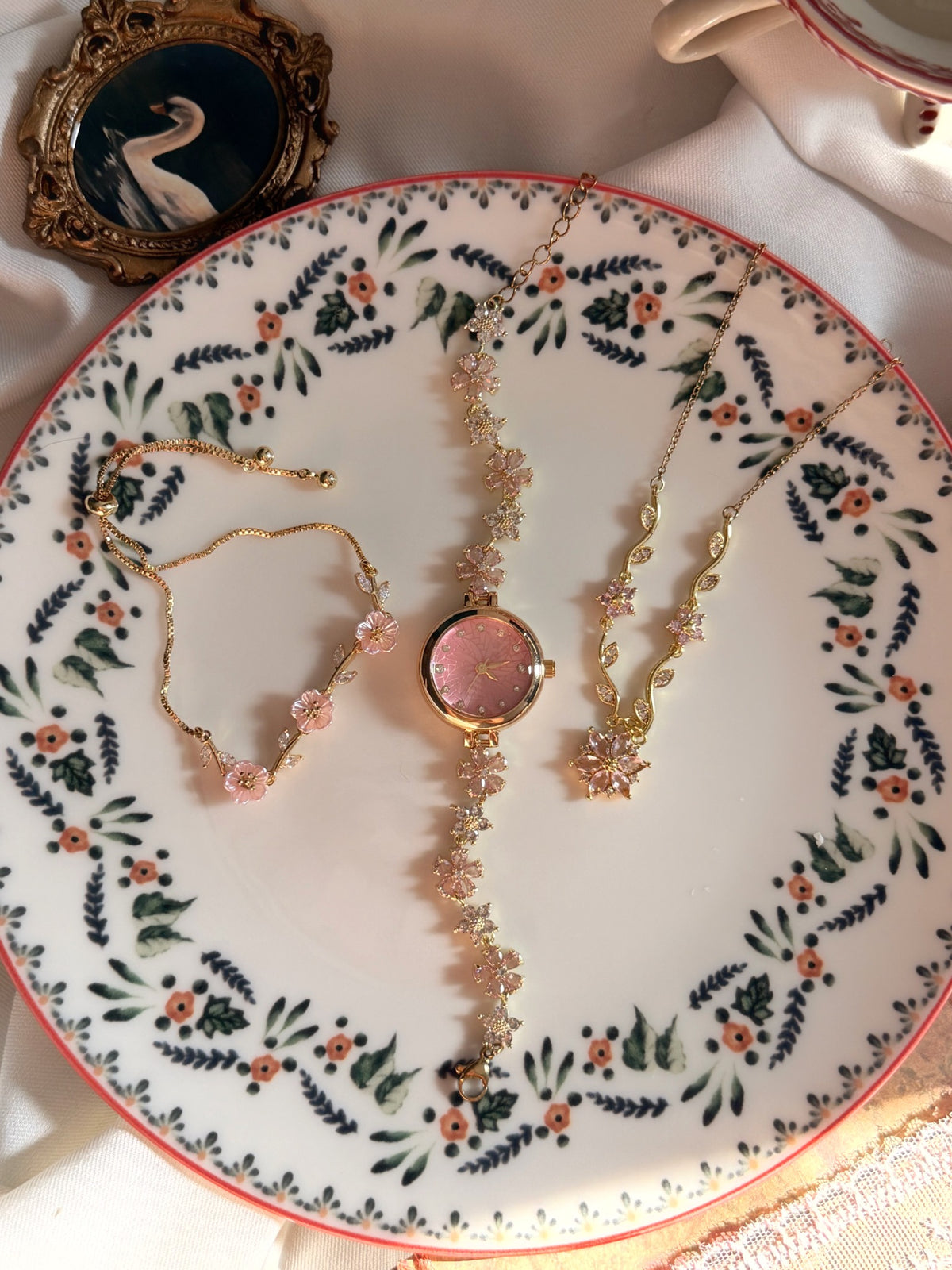 Pembe kadranlı gold kadın saat, pembe sedef çiçekli bileklik ve pembe çiçek dal detaylı kolyeden oluşan 3'lü kadın takı seti