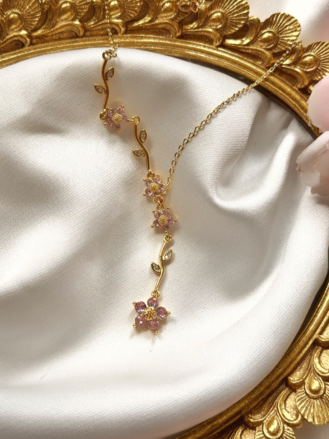 Pembe çiçekli sarkıt ve dal detaylı gold kadın Y kolyenin saten üzerinde tam görünümü