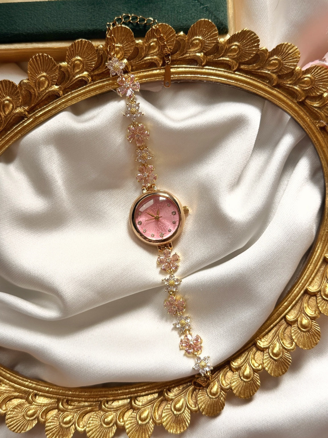 Pembe kadranlı çiçekli gold kadın saatin saten ve gold çerçeve içinde tam görünümü