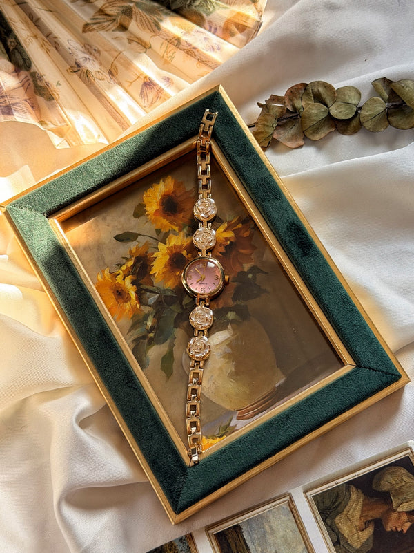 Beyaz gül motifli pembe kadranlı gold metal kadın saatin tam boy görünümü