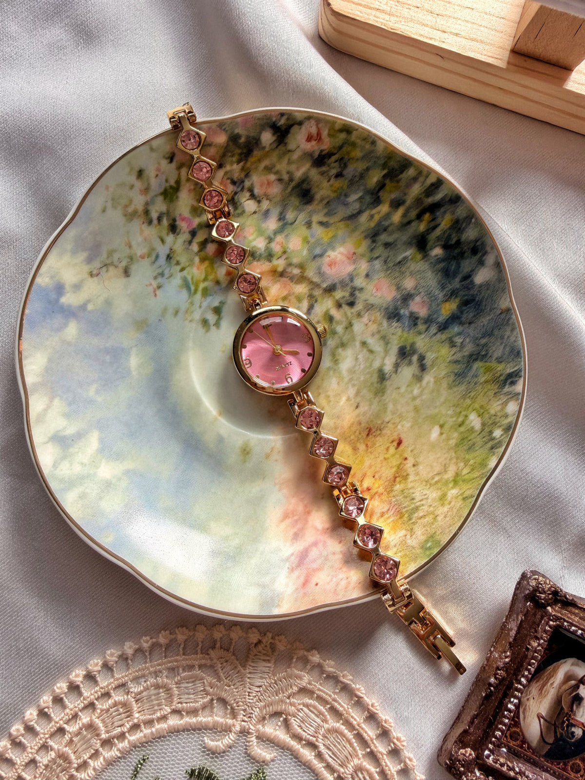 Vintage çiçek desenli tabakta pembe kadranlı gold kadın bileklik saat ve pembe taşlı metal kordon