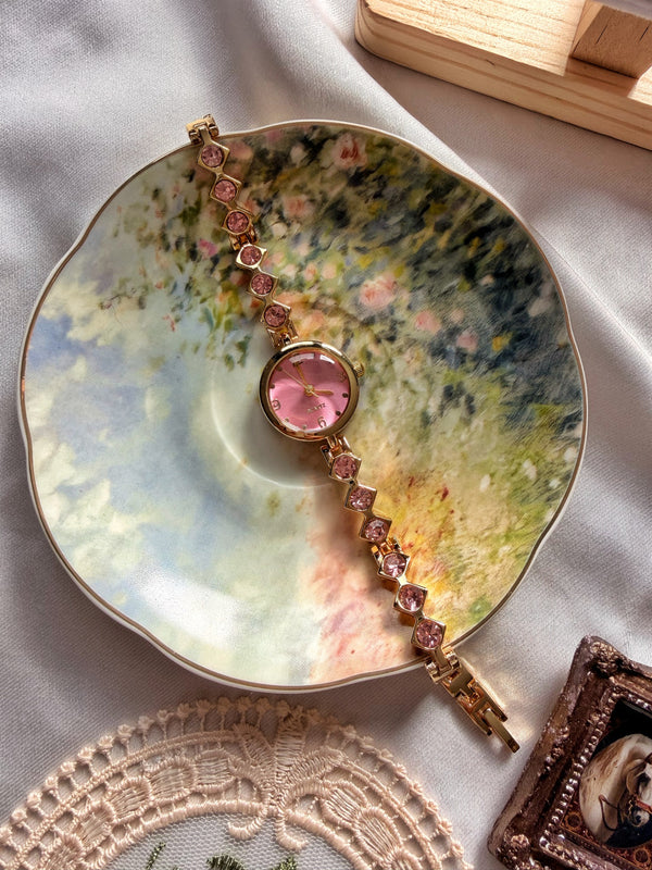 Vintage çiçek desenli tabakta pembe kadranlı gold kadın bileklik saat ve pembe taşlı metal kordon