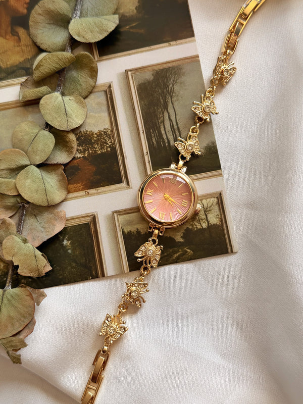 10 parçalı takı setine dahil pembe kadranlı kelebek detaylı gold kadın saatin gerçek ürün fotoğrafı