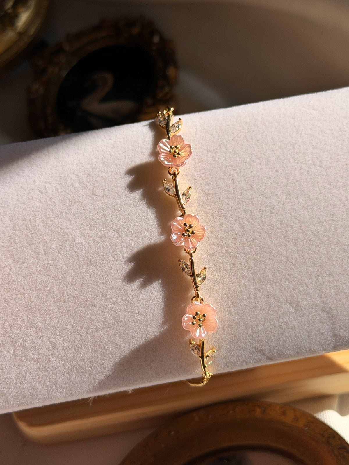 Pembe sedef çiçekli ayarlanabilir gold kadın bileklik stand üzerinde