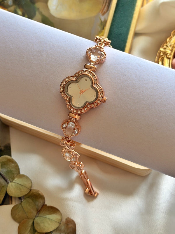 Taşlı yonca kadranlı rose gold kadın saatin beyaz stand üzerinde kordon detaylarıyla görünümü