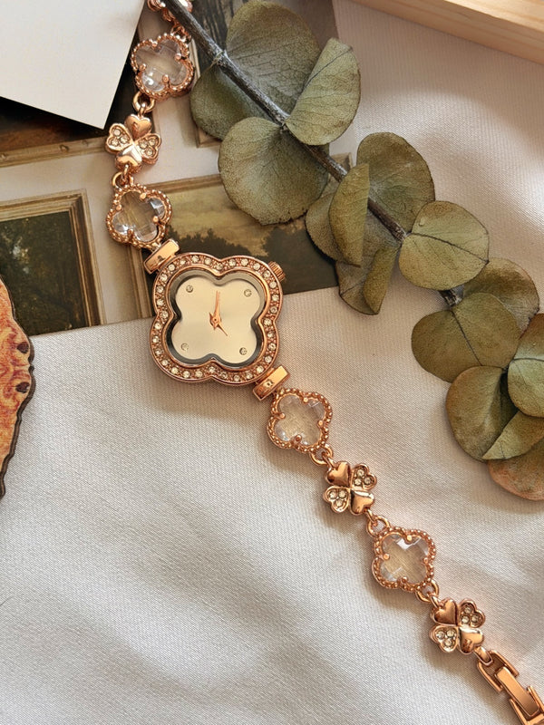 Rose gold yonca saat kadranı ile şeffaf taşlı ve kelebek motifli kordonun yakın görünümü