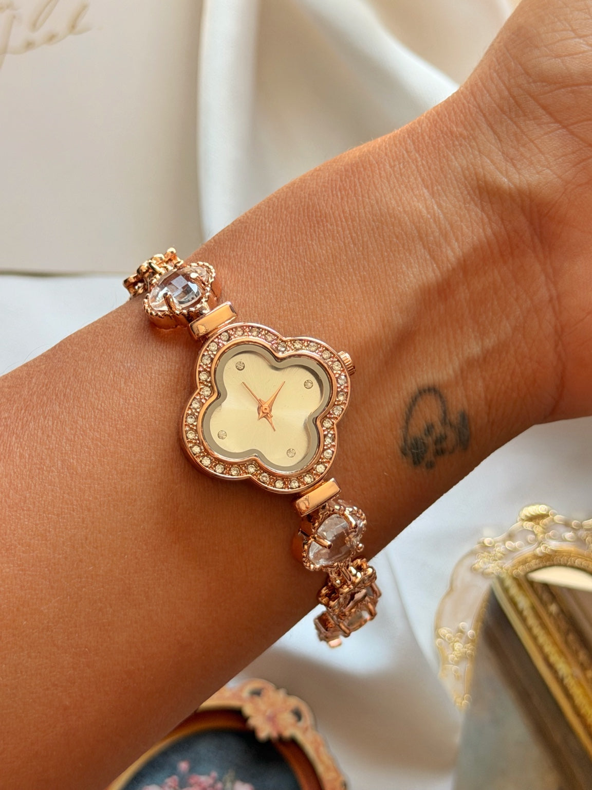 Rose gold yonca detaylı taşlı kadın bileklik saatin bilekte yakın görünümü