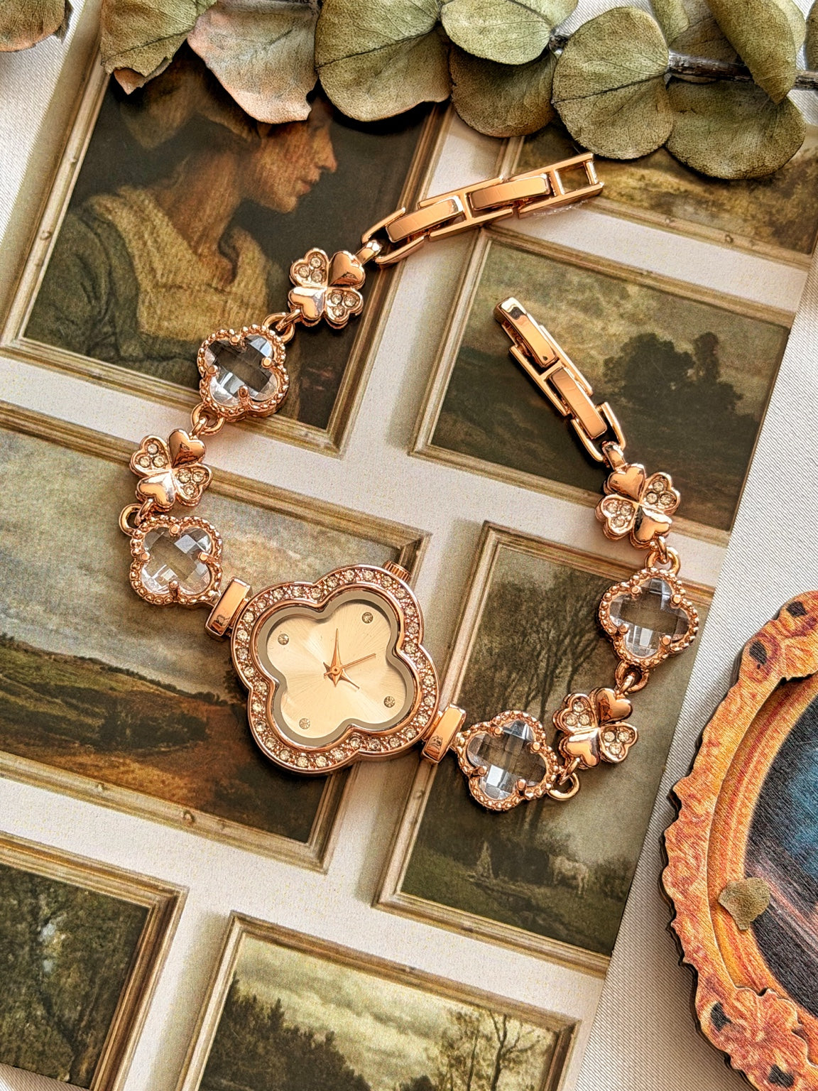 Şeffaf taşlı yonca ve kelebek detaylı rose gold kadın saatin açık kordonla tam görünümü