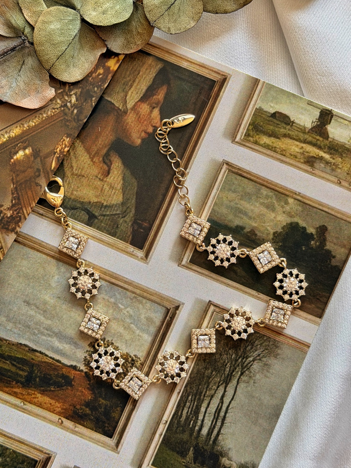 Kare taş ve çiçek motifli gold kadın bilekliğin vintage tablo üzerinde açık görünümü