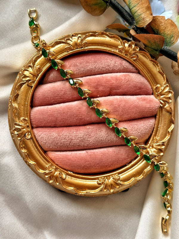 Zümrüt yeşili markiz taşlı gold kadın bilekliğin pembe kadife sunumda görünümü